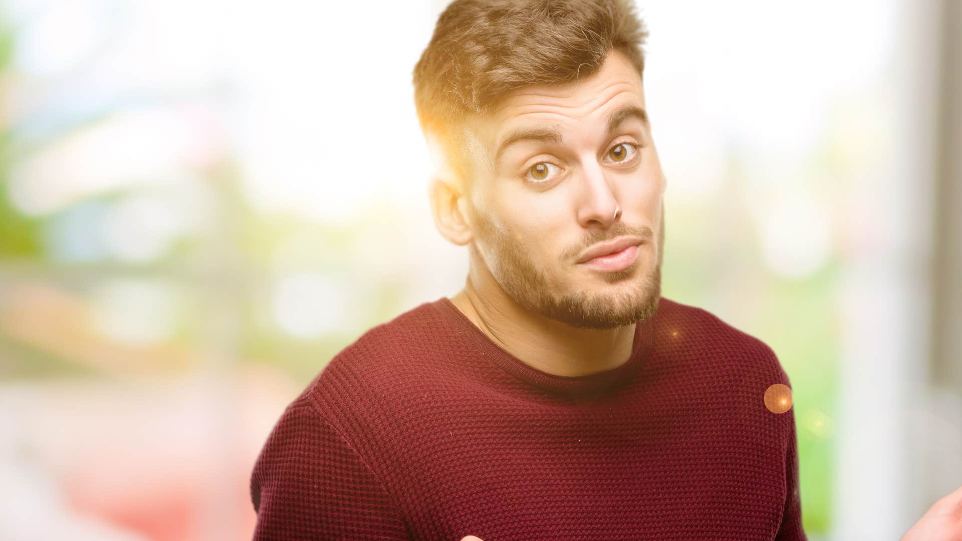 man in red shirt saying it's not that deep as he stares at camera