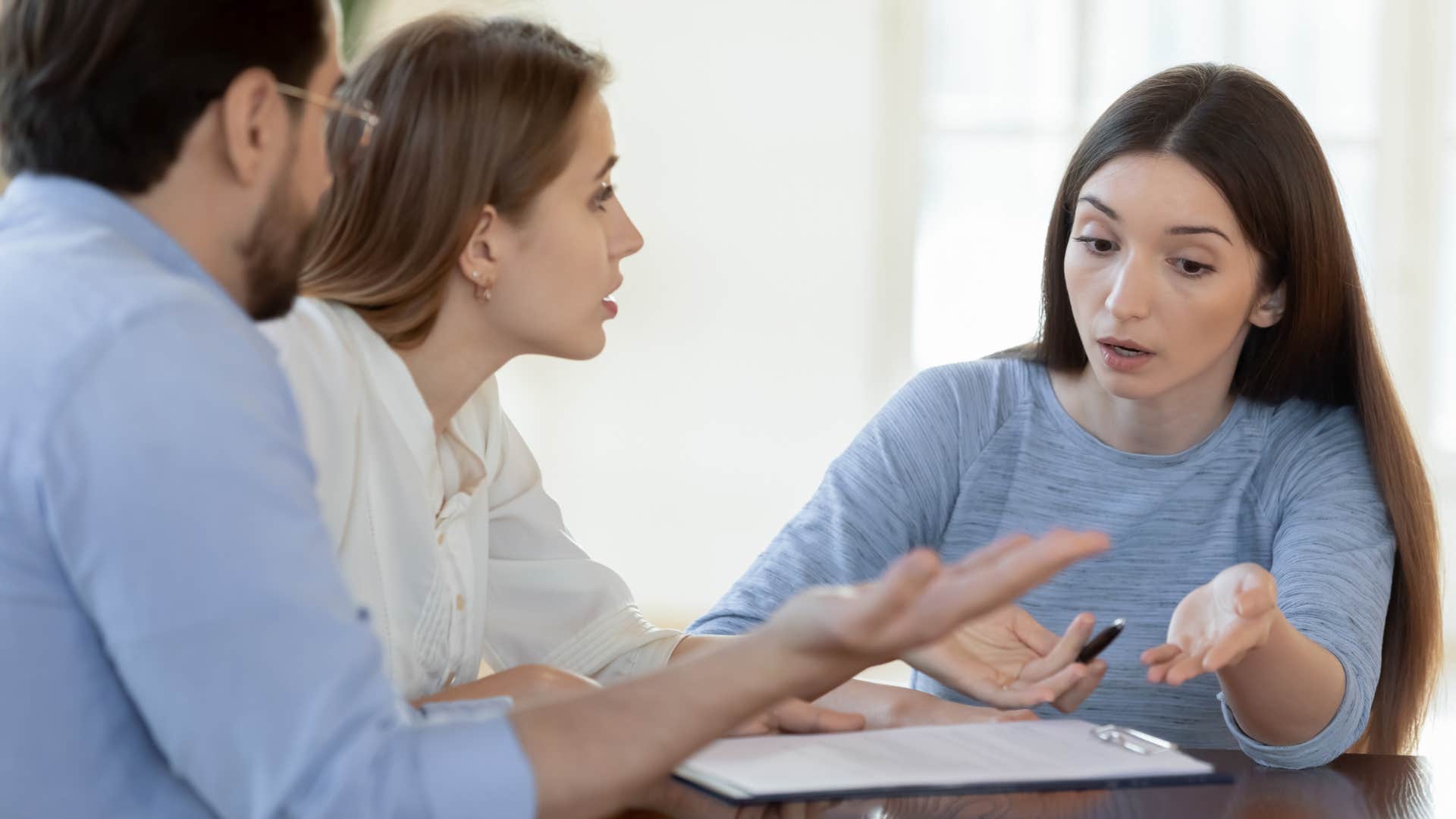 angry woman telling a couple everyone knows that