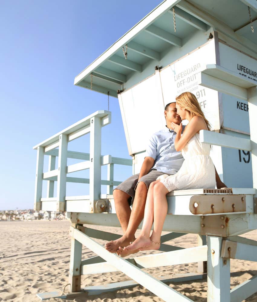 Charming couple embrace on lifegaurd shack at Manhattan Beach