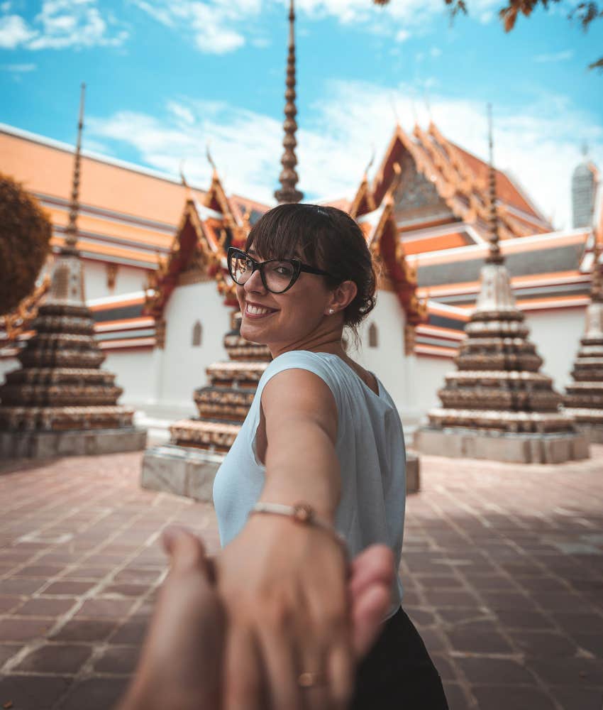 hand holding couple enjoy life exploring Thai temple