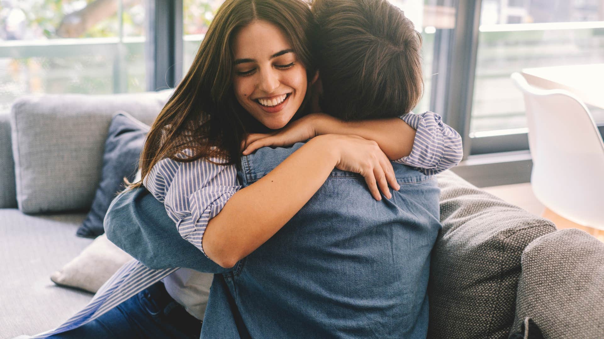 Aggressive and controlling daughter smiles hugging her dad who is overly generous