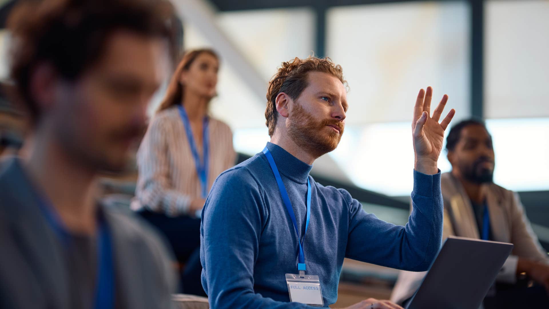 man in blue shirt raising hand as they admit when they don't know