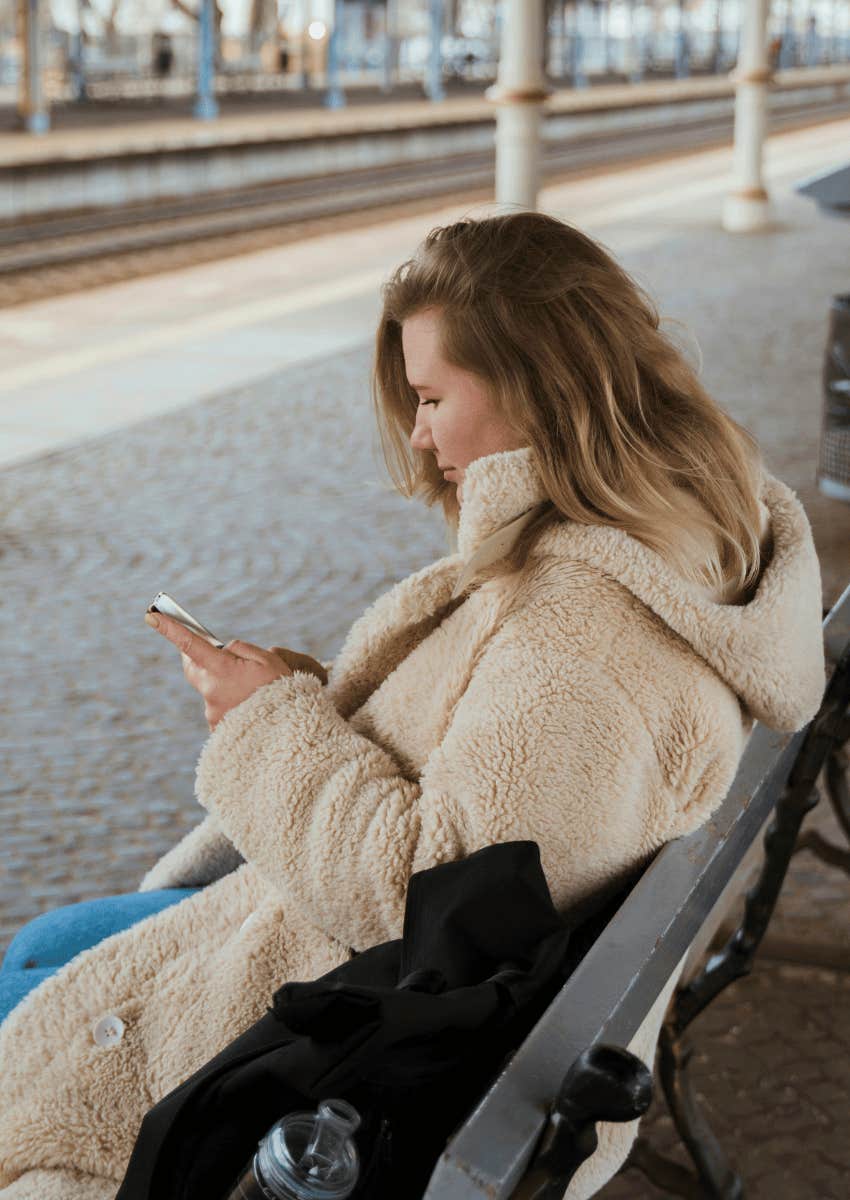 woman sitting alone checking her phone