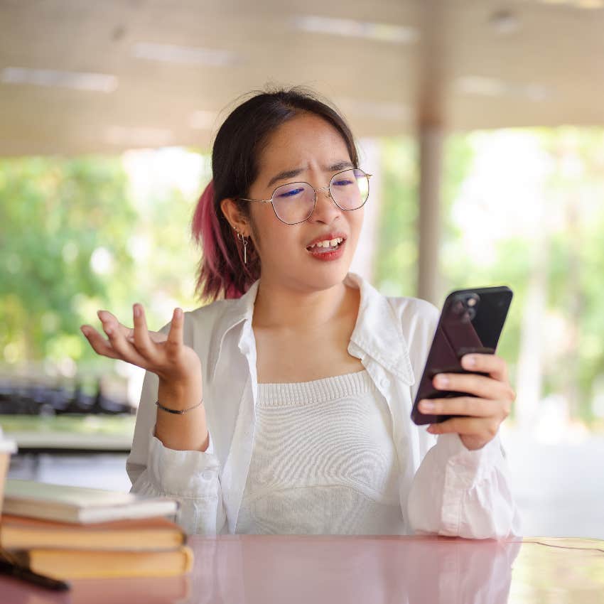 woman confused while texting on smartphone