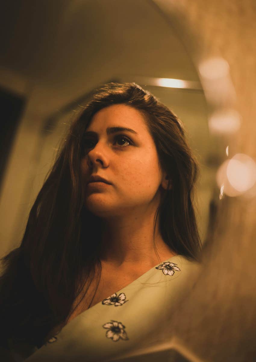 woman looking at her reflection in a mirror