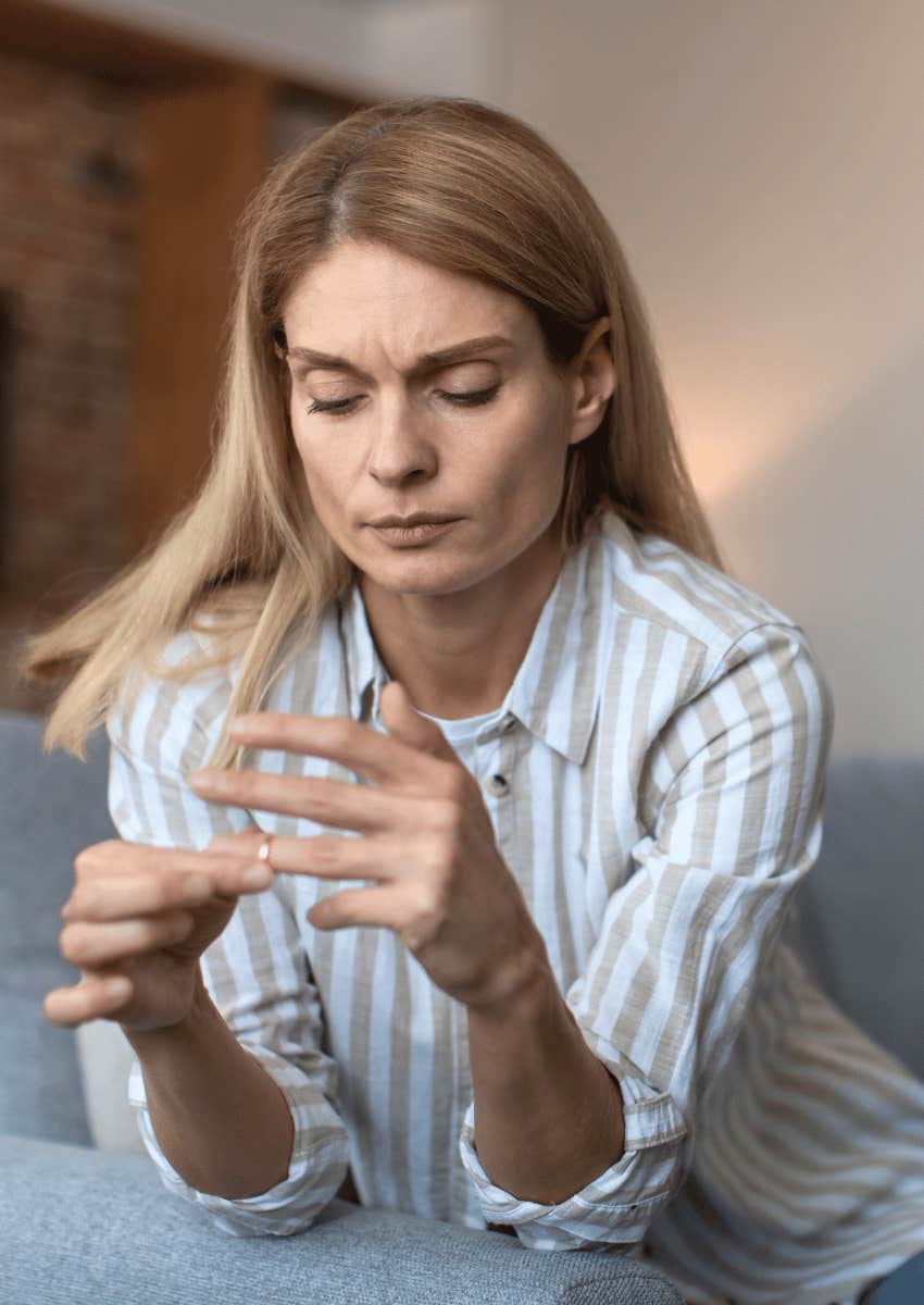 woman pulling off wedding ring during divorce process
