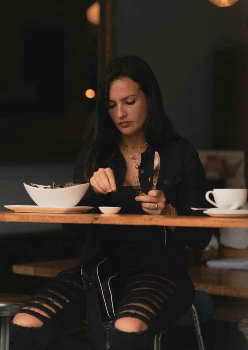 woman sitting alone eating dinner