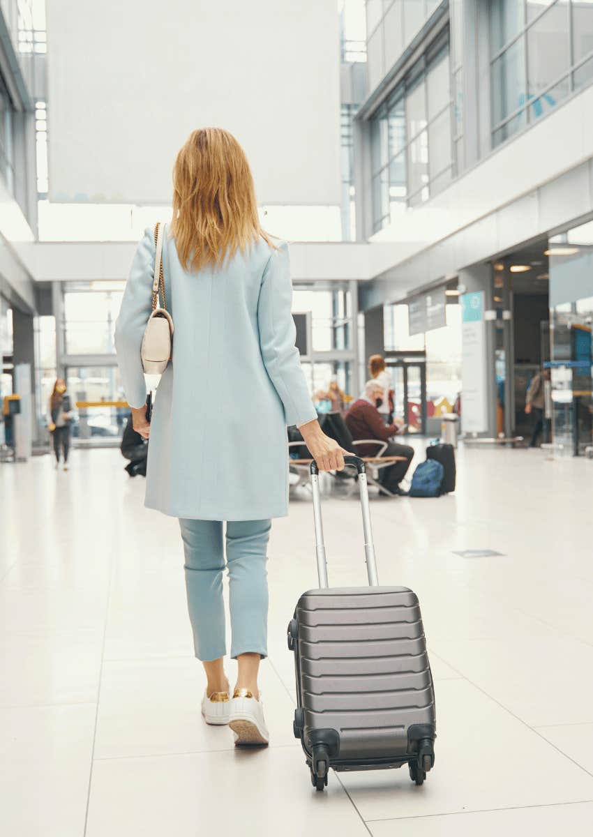 woman with a suitcase walking through airport