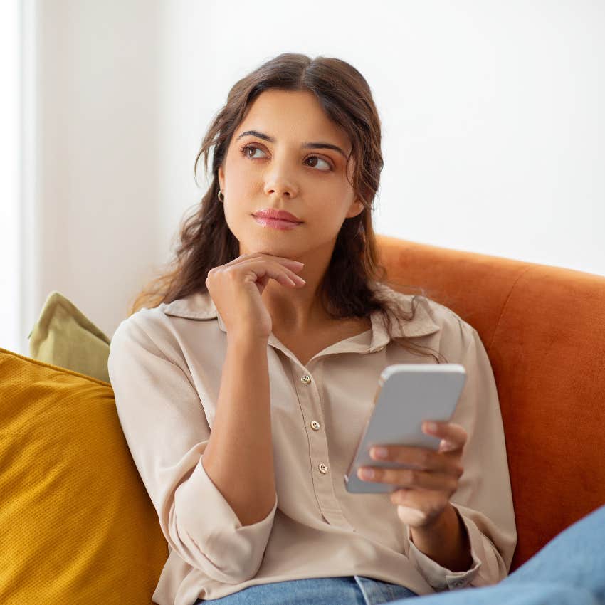 highly intelligent woman thinking while holding smart phone