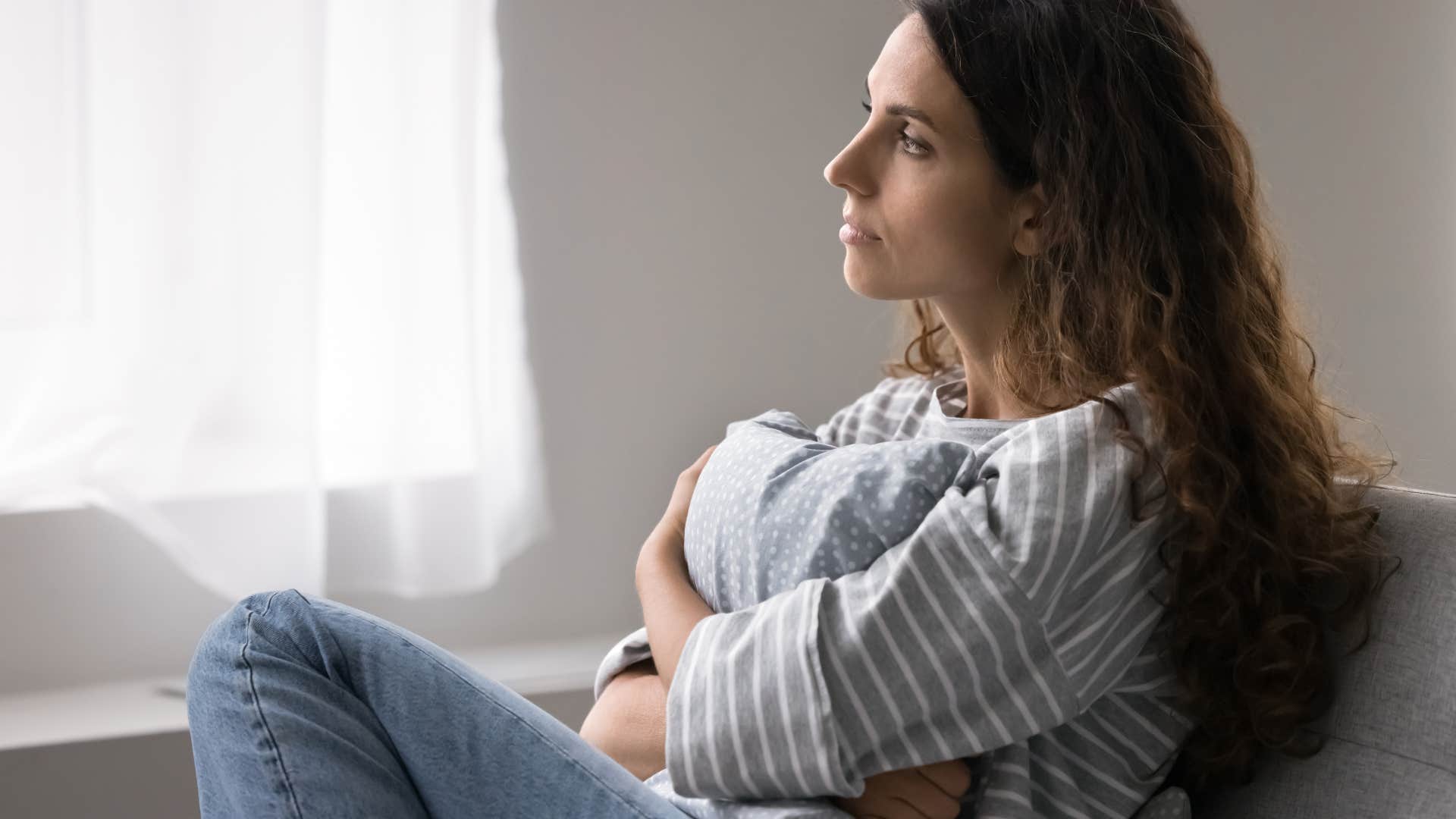 pensive woman telling herself i'm just overthinking it again as she stares off into space