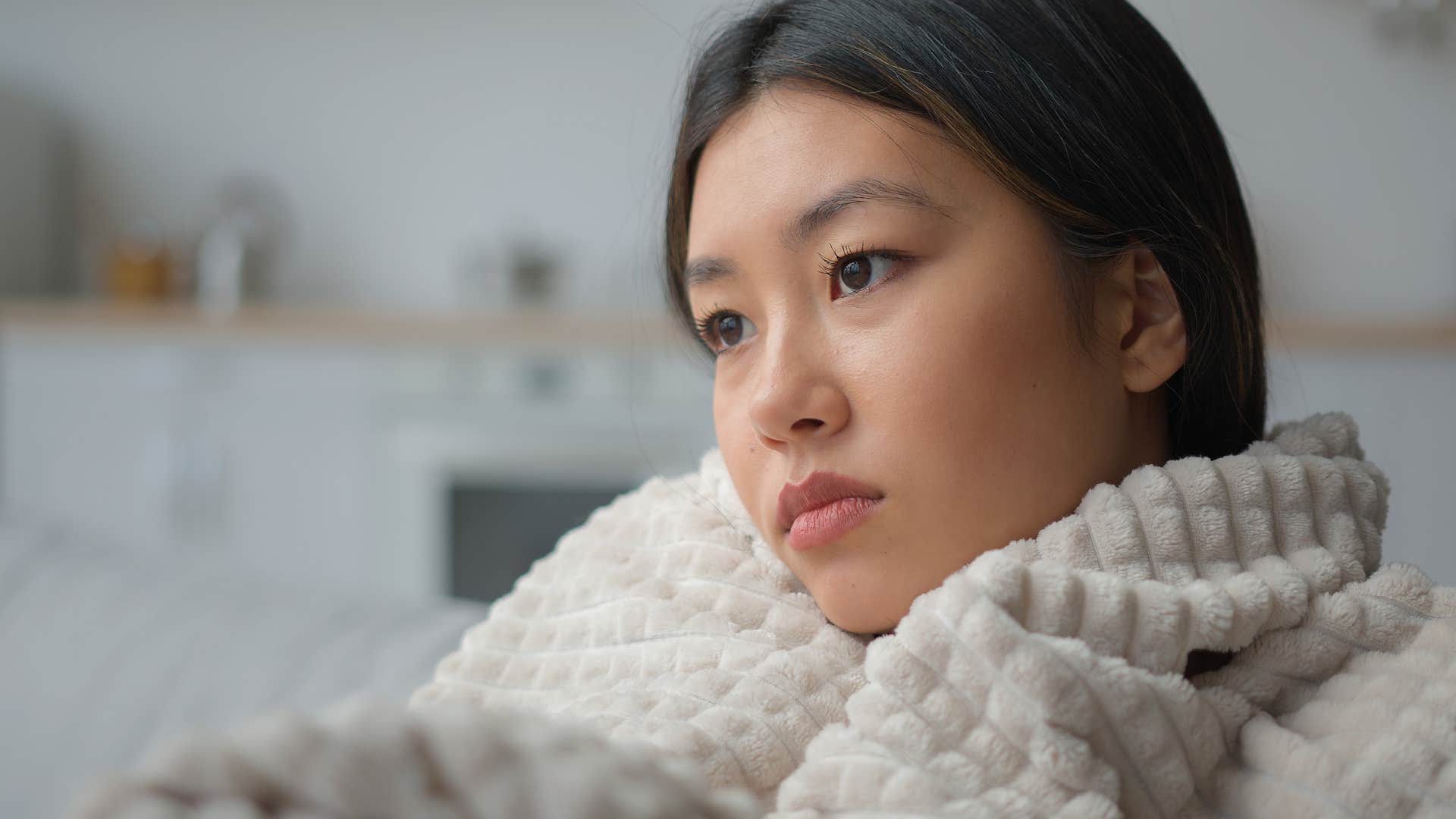 woman experiencing disbelief while sitting alone at home