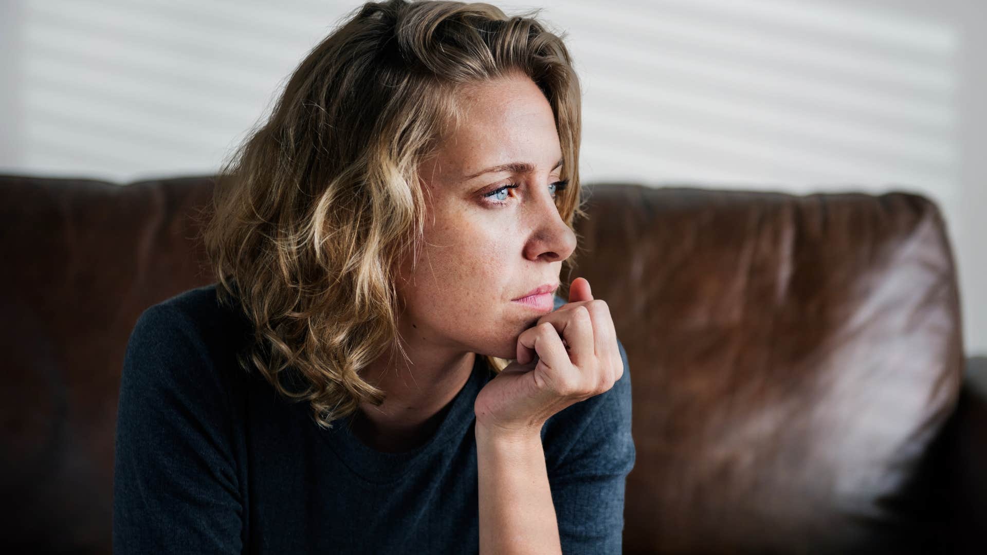sad woman facing fear and anxiety at home after a loss