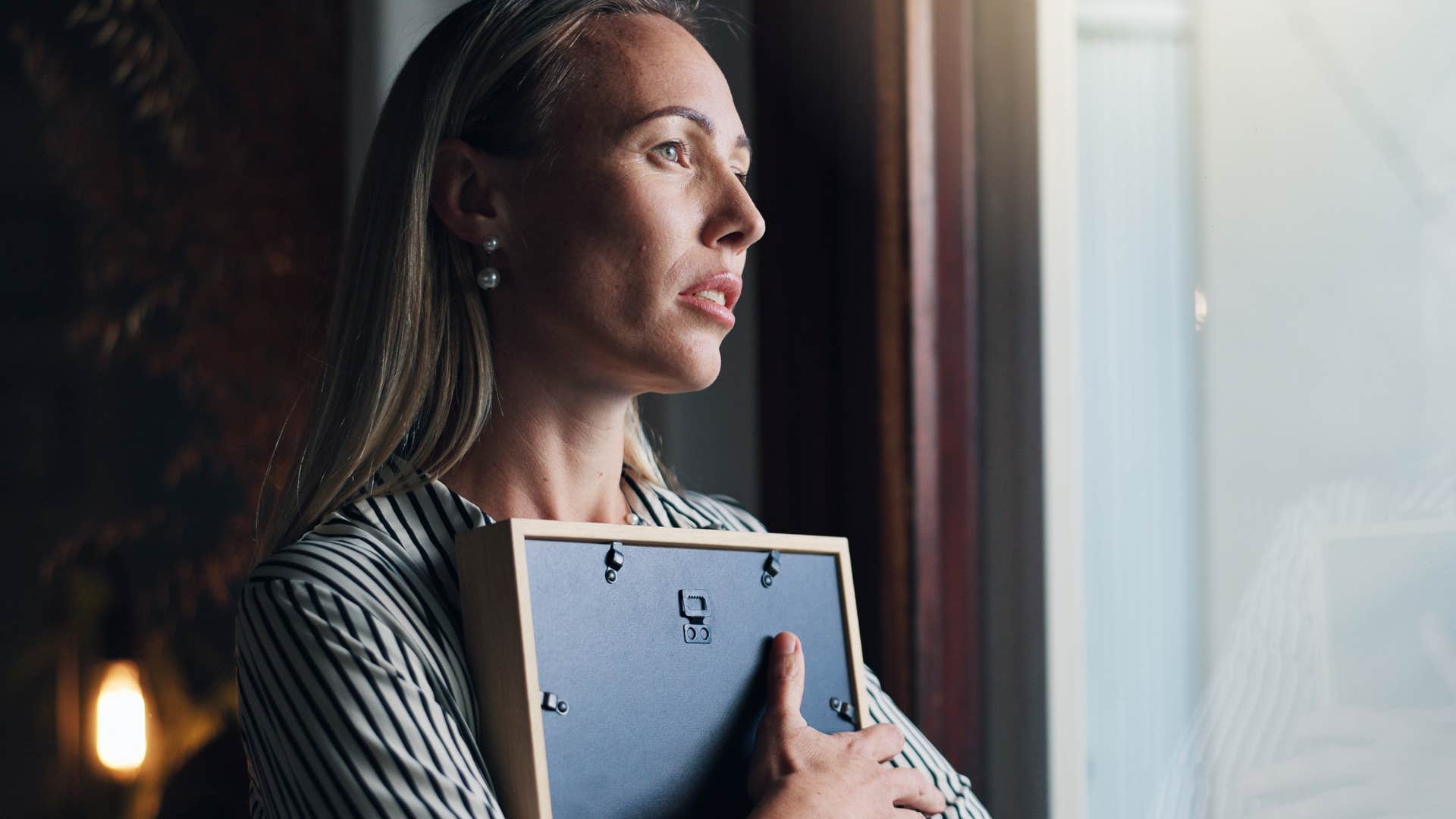 sad woman facing regret holding a photo in her hands