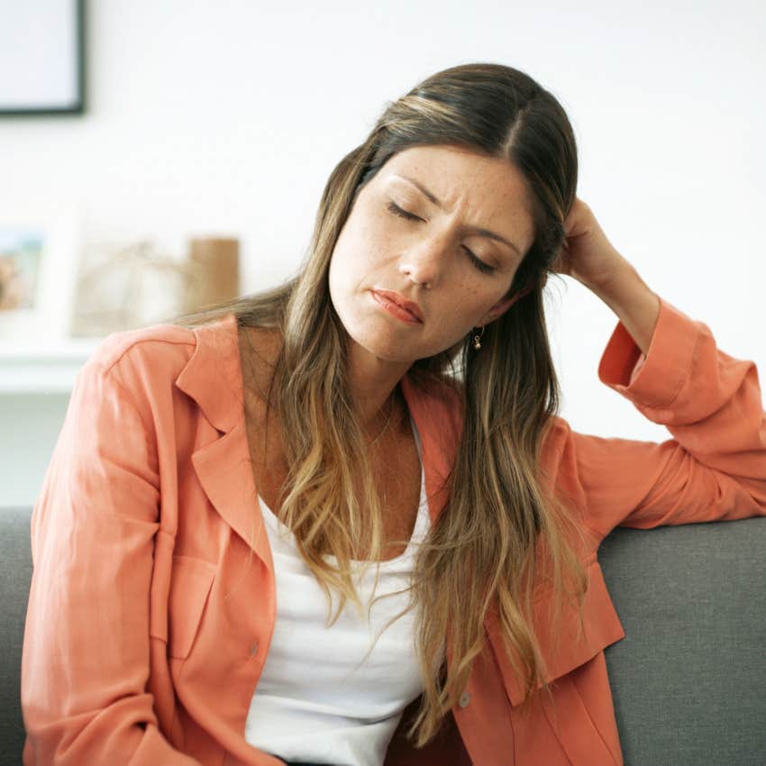 annoyed woman sitting on couch at home