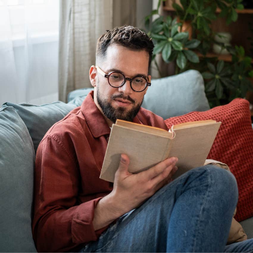 man excited about spending alone time at home reading a book