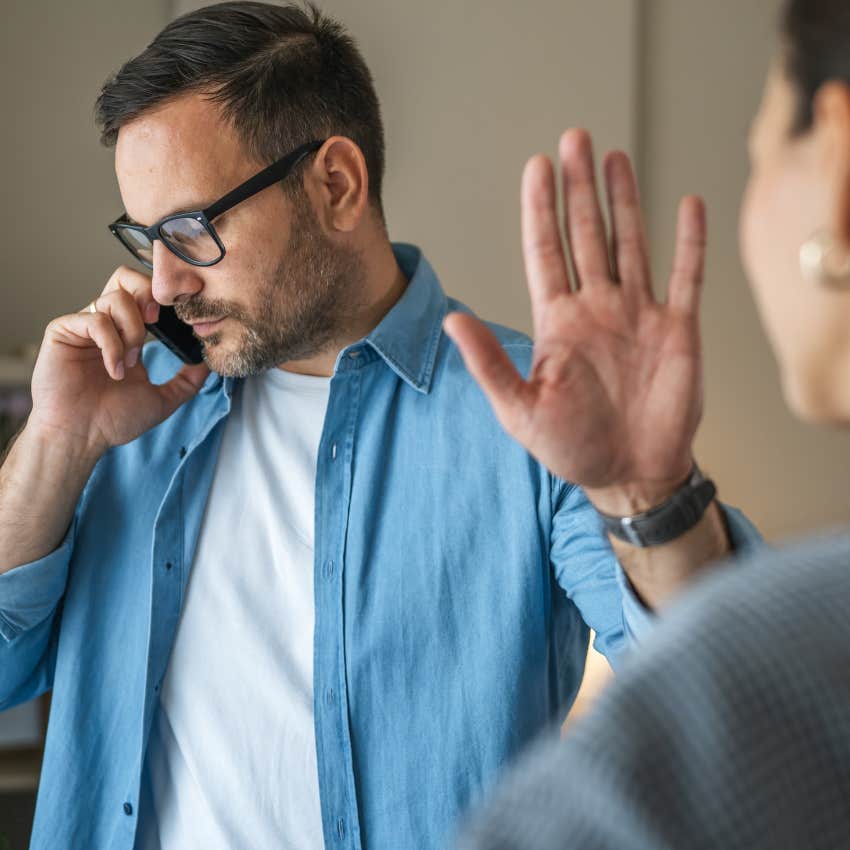 Man saying "that's not my problem" with his hand up this partner.