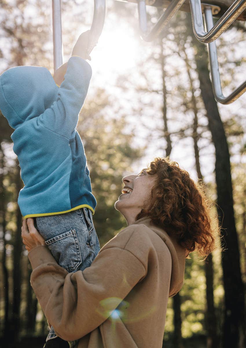 young mom being careful with child on playground
