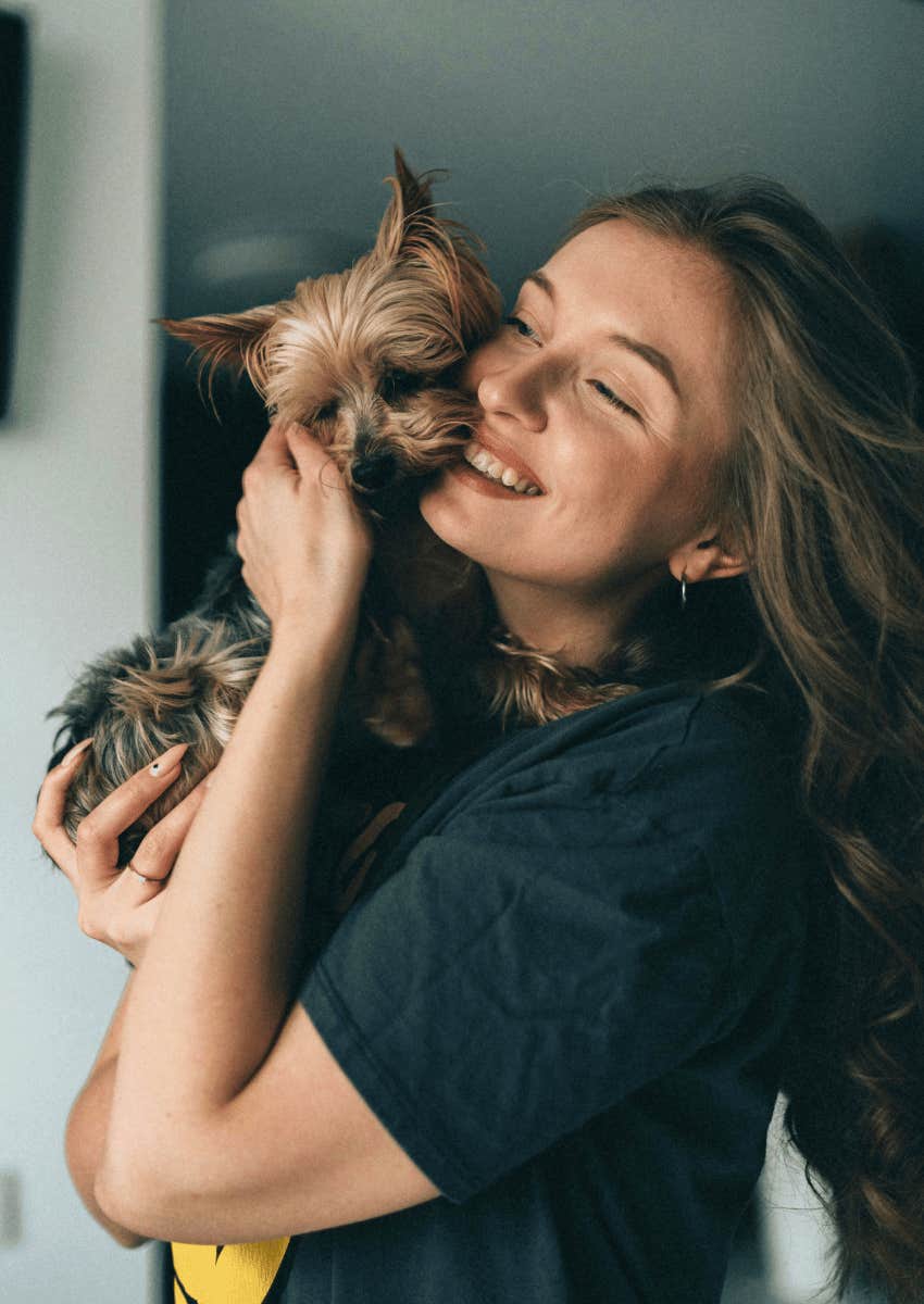 young woman hugging her tiny dog close