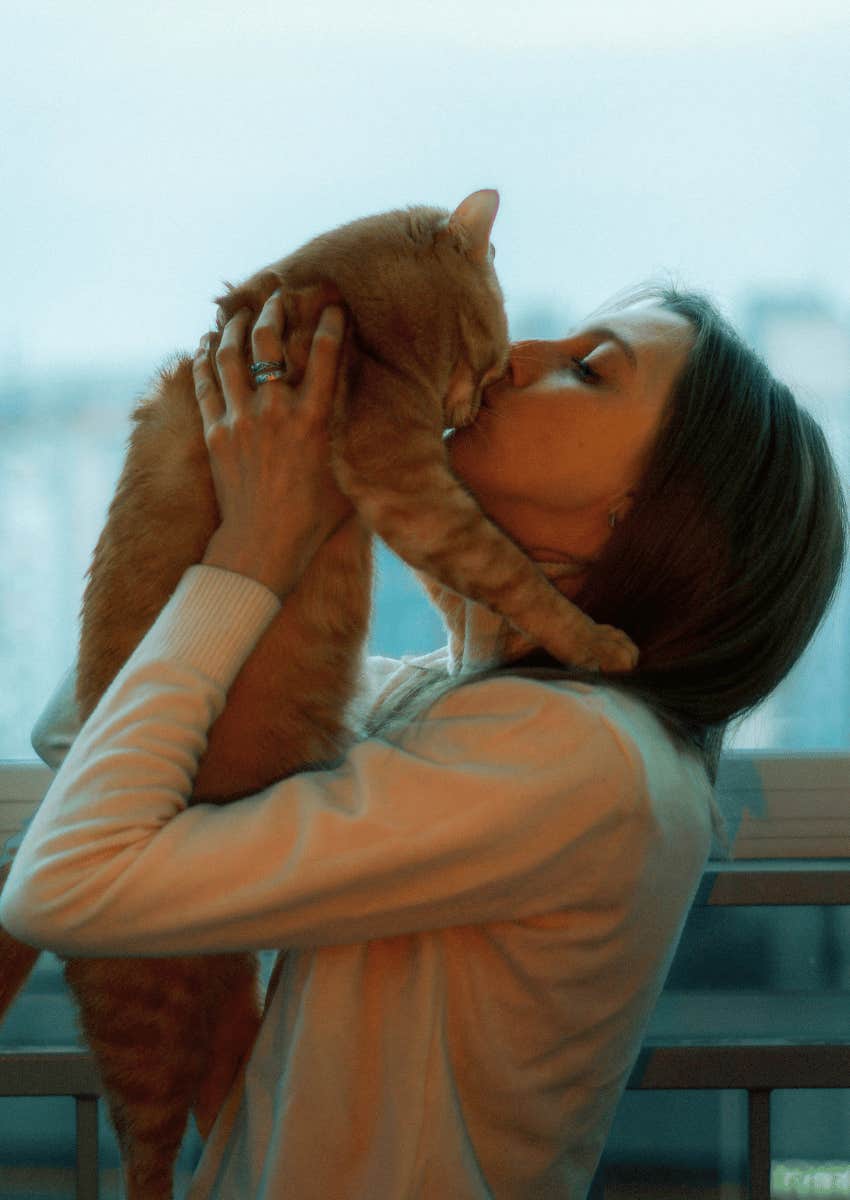 young woman kissing her cat's nose