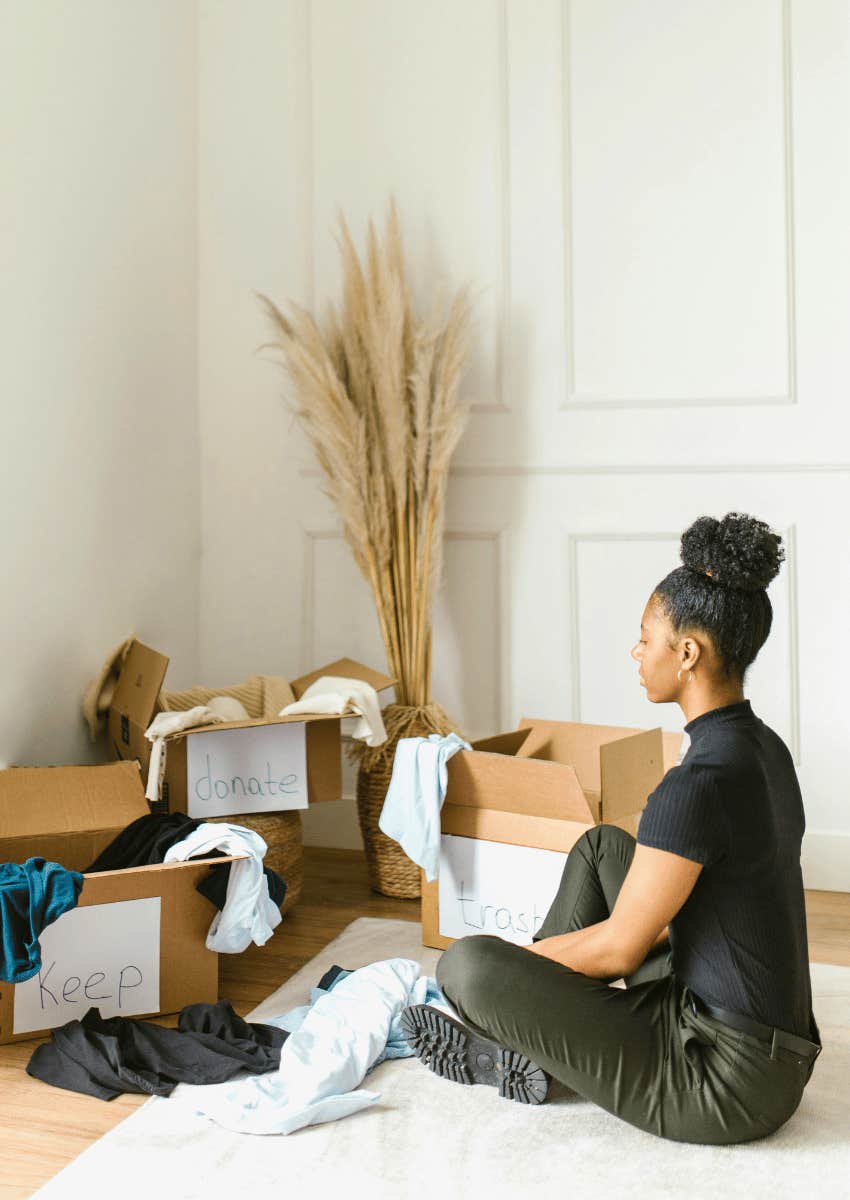 young woman sorting clothes into donation boxes