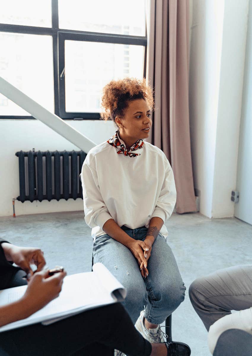 young woman in a support group listening to others