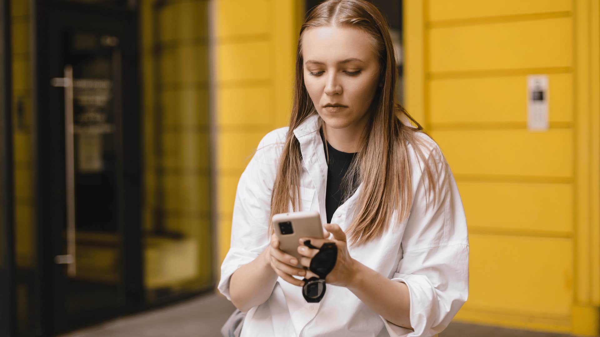 woman texting a friend she is trying to phase out that she's keeping things private right now