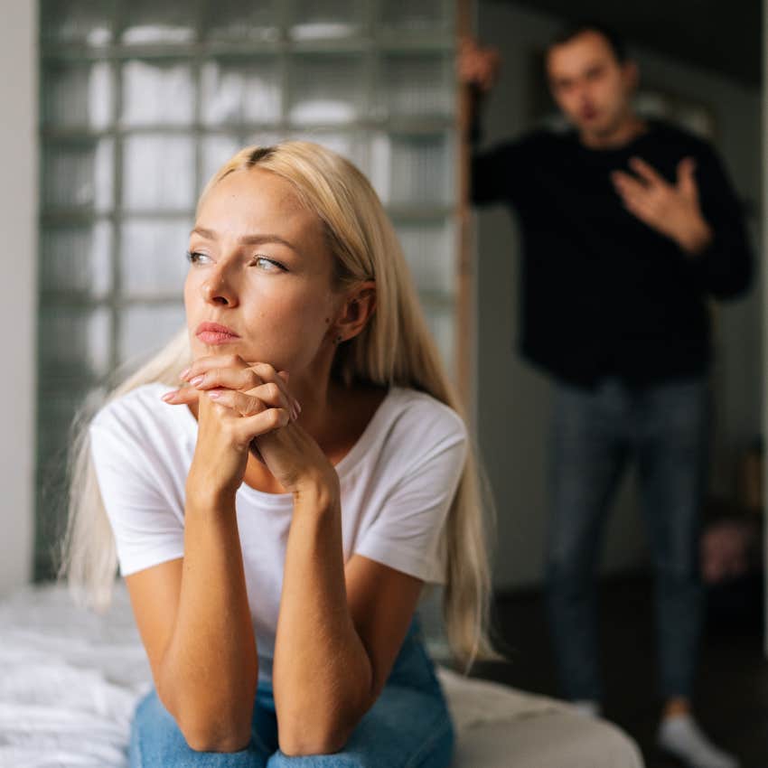 woman upset with partner sitting on bed