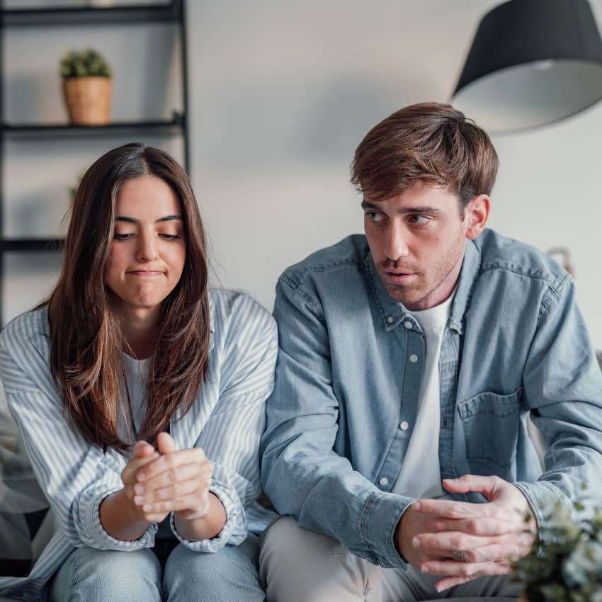 young couple sitting together on couch after fight