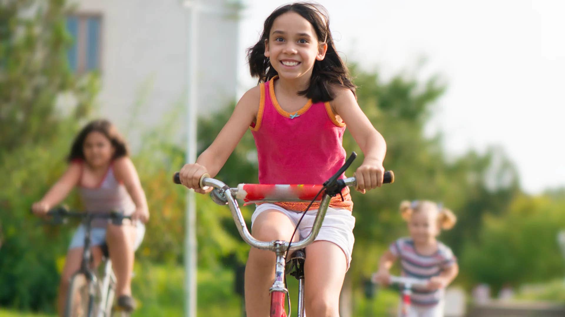 group of young kids riding bikes outside