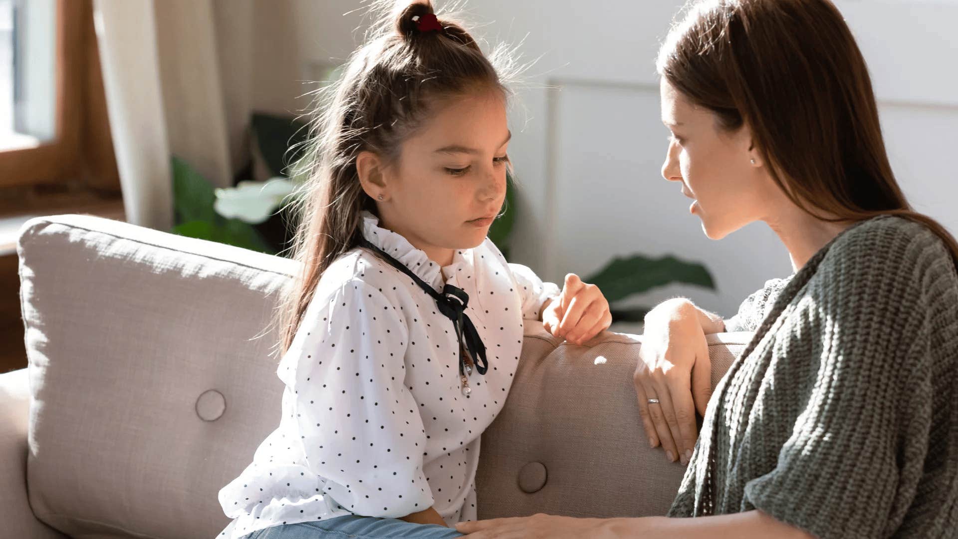 woman having serious conversation with young daughter telling her to get over it