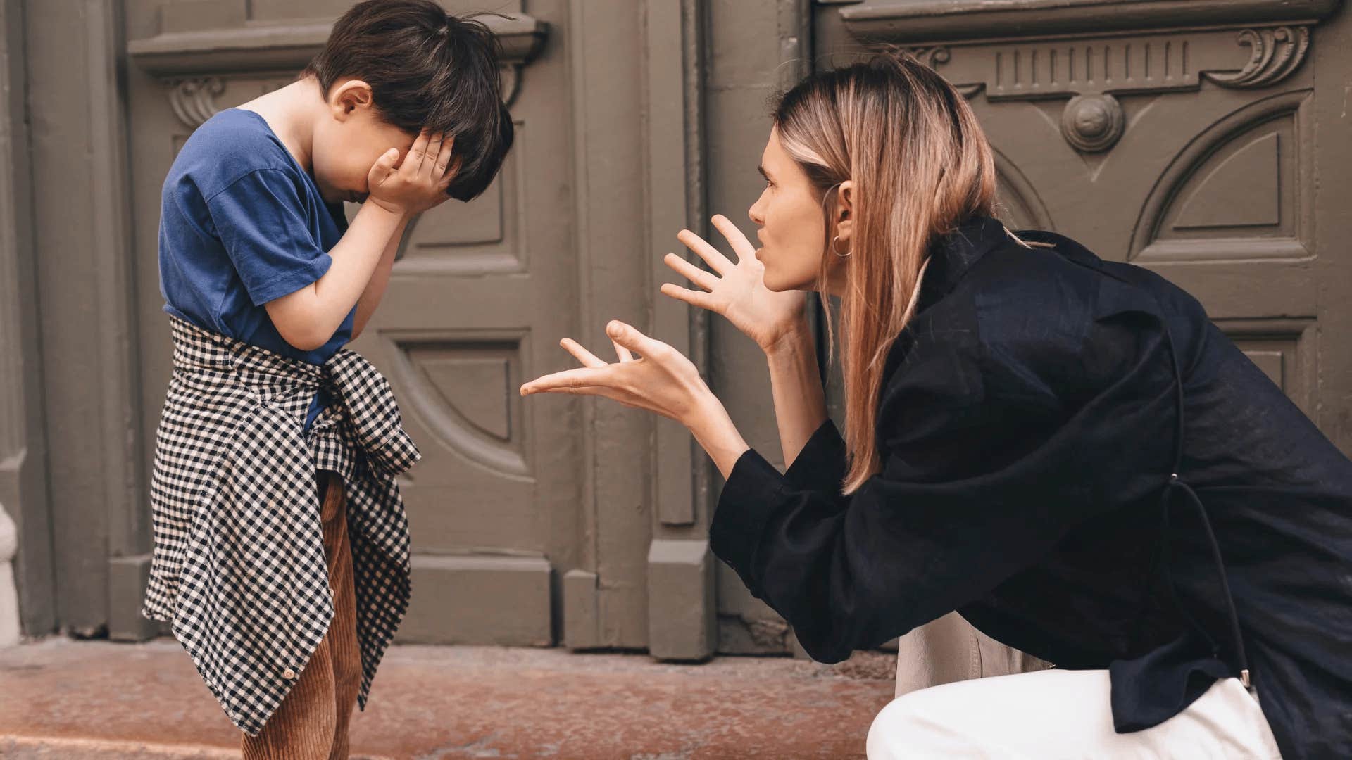 woman scolding crying young son telling him i'll give you something to cry about