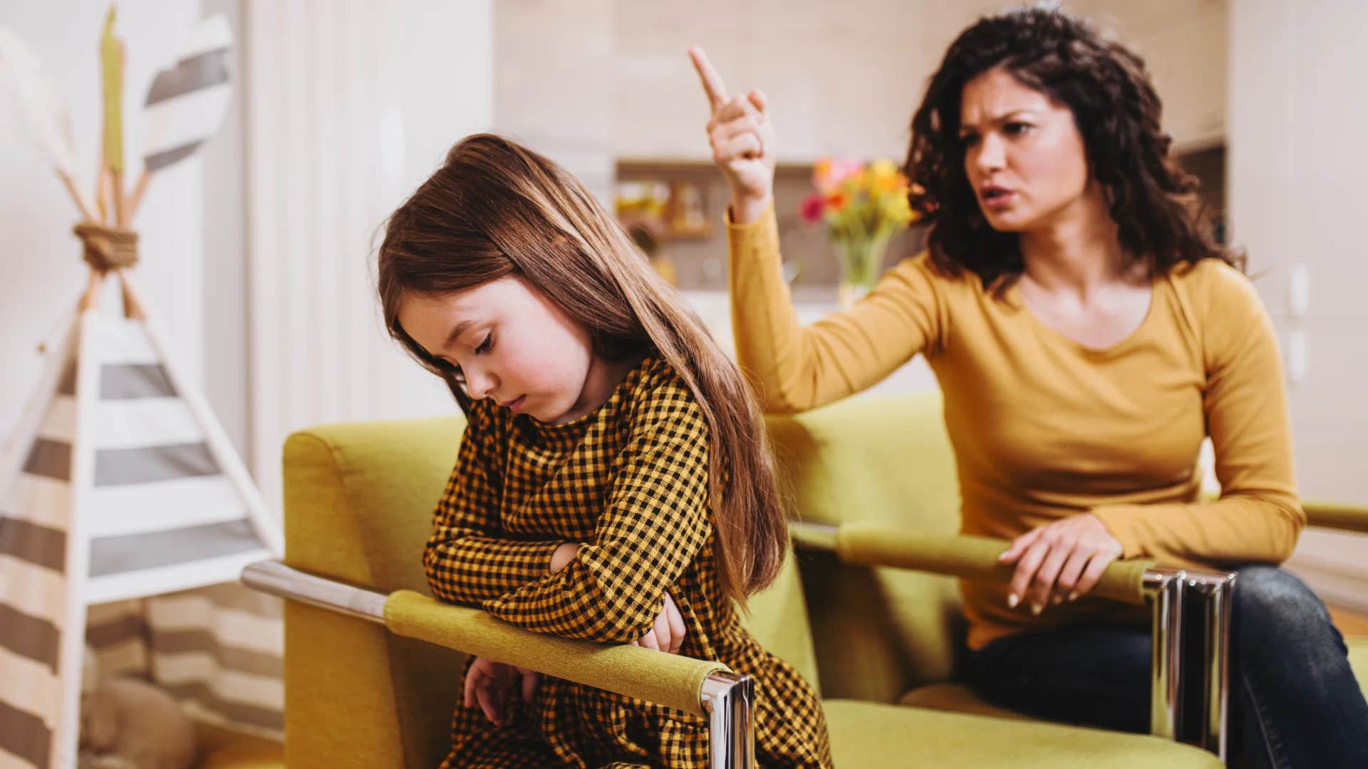 angry mom scolding her young daughter saying wait until your father gets home