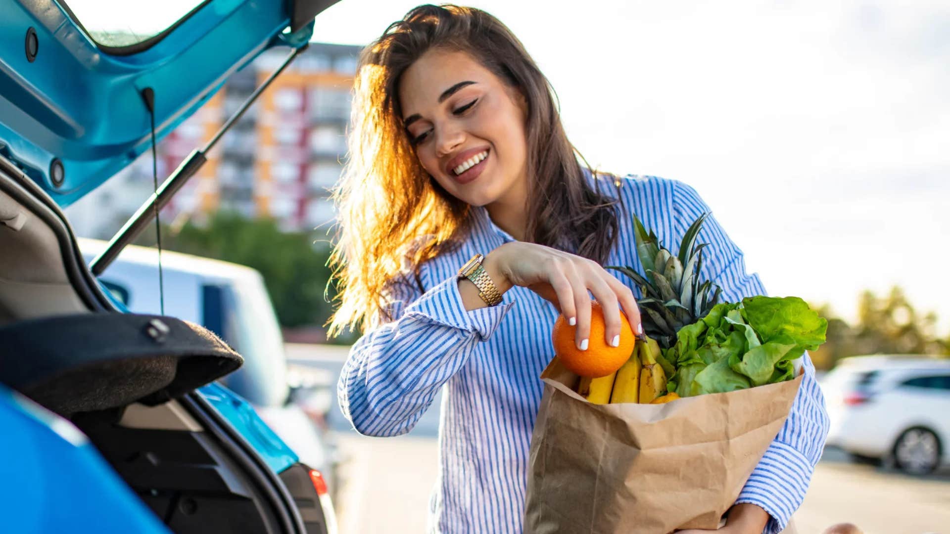 woman putting groceries in her car
