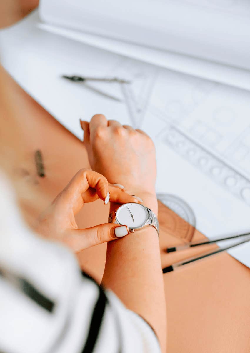 close-up of woman looking down at her watch