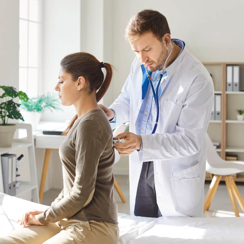 male doctor using stethoscope on female patient