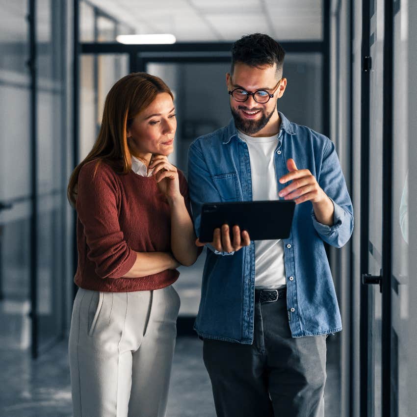 co-workers looking at tablet in office after company implements cost-cutting measures