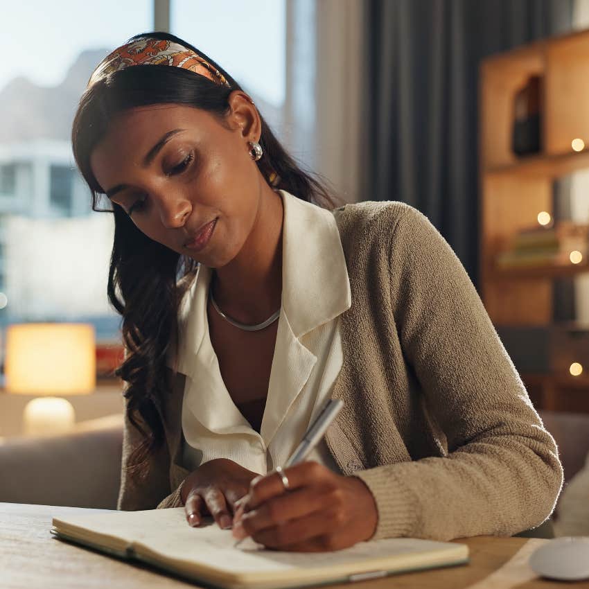 intelligent woman writing in notebook avoiding em dashes