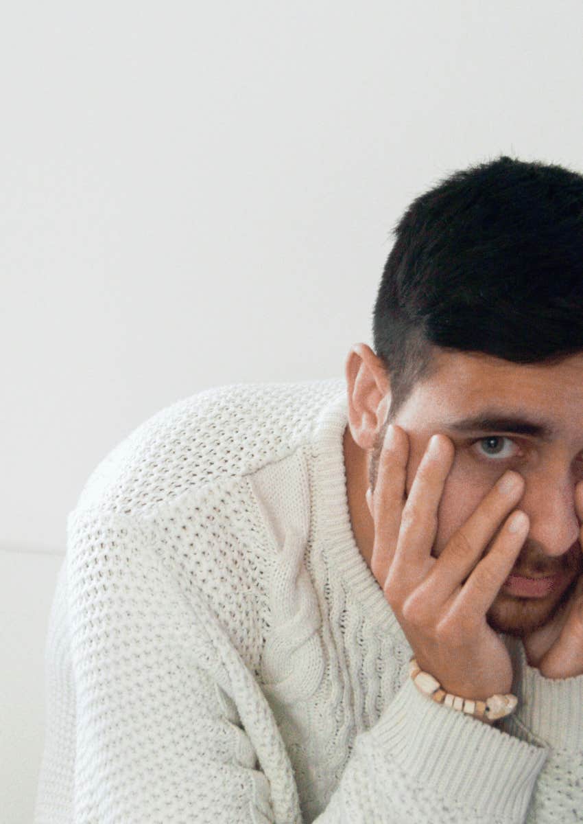 embarrassed man slumped over hiding his face