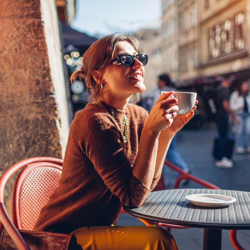 woman with strong yang energy at outdoor cafe drinking coffee
