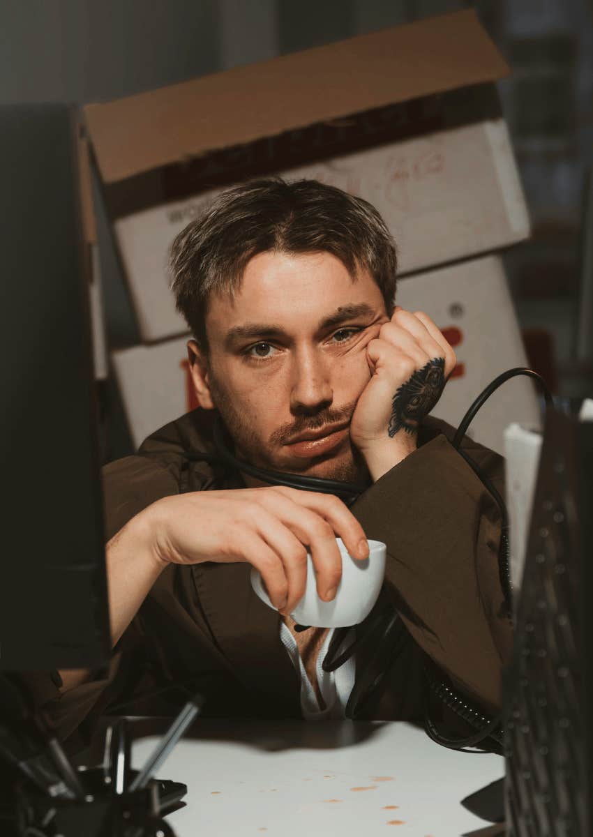 exhausted millennial sitting at messy work desk