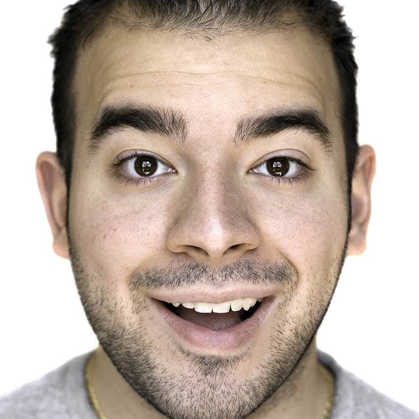 man with thick eyebrows smiling