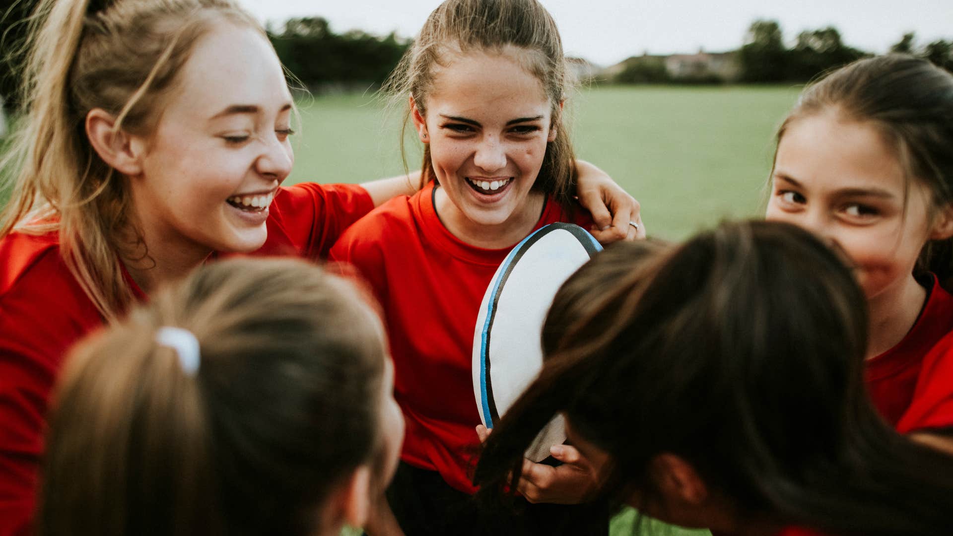 young girls playing rugby together in a summer league