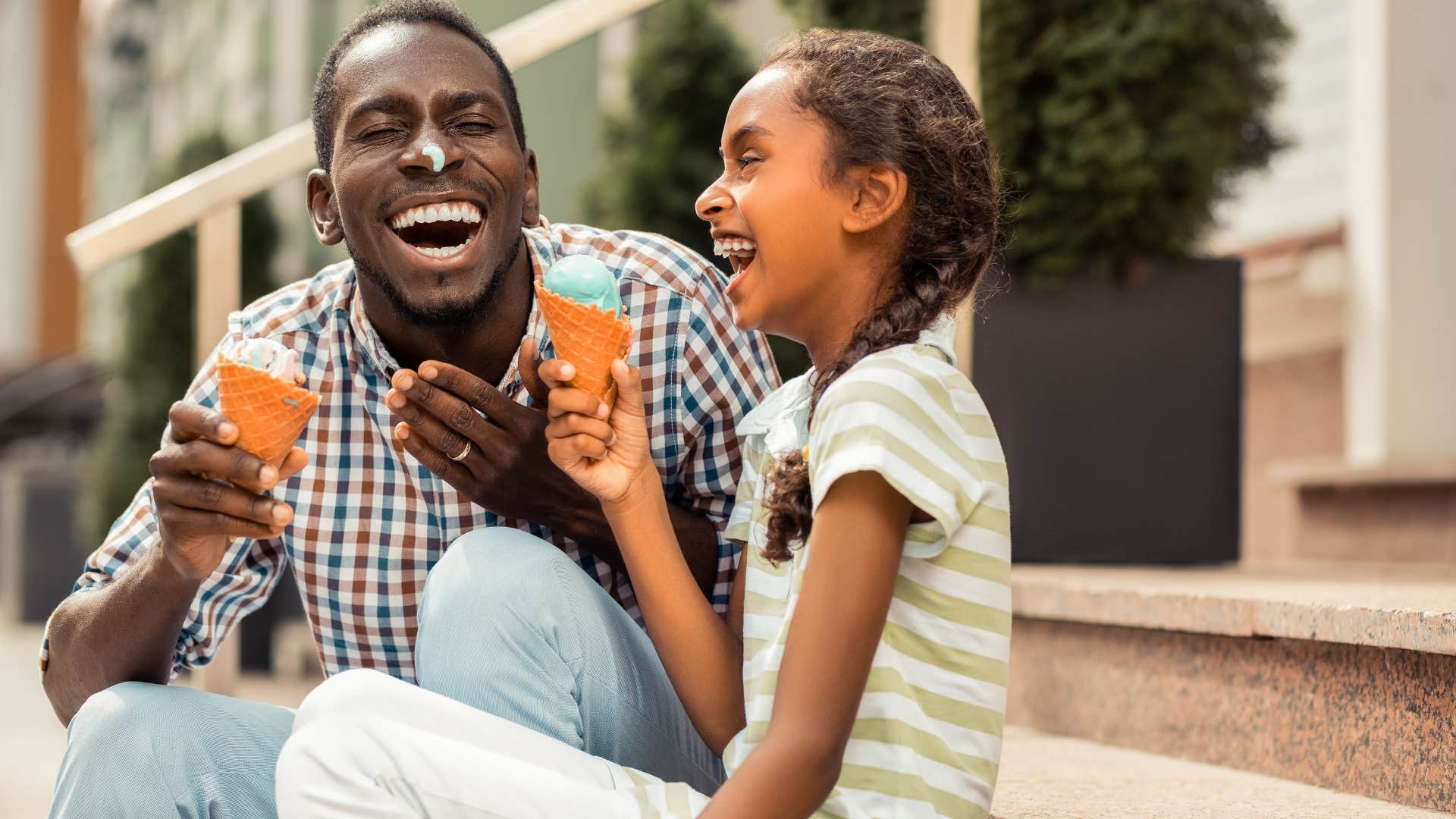 dad taking his daughter out in the summer for after dinner treat eating ice cream