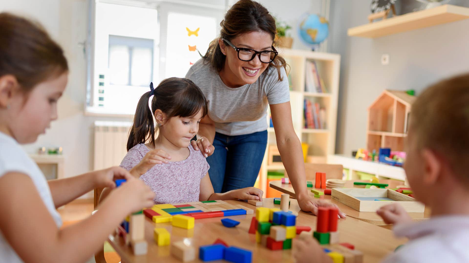 teacher helping kids in daycare play