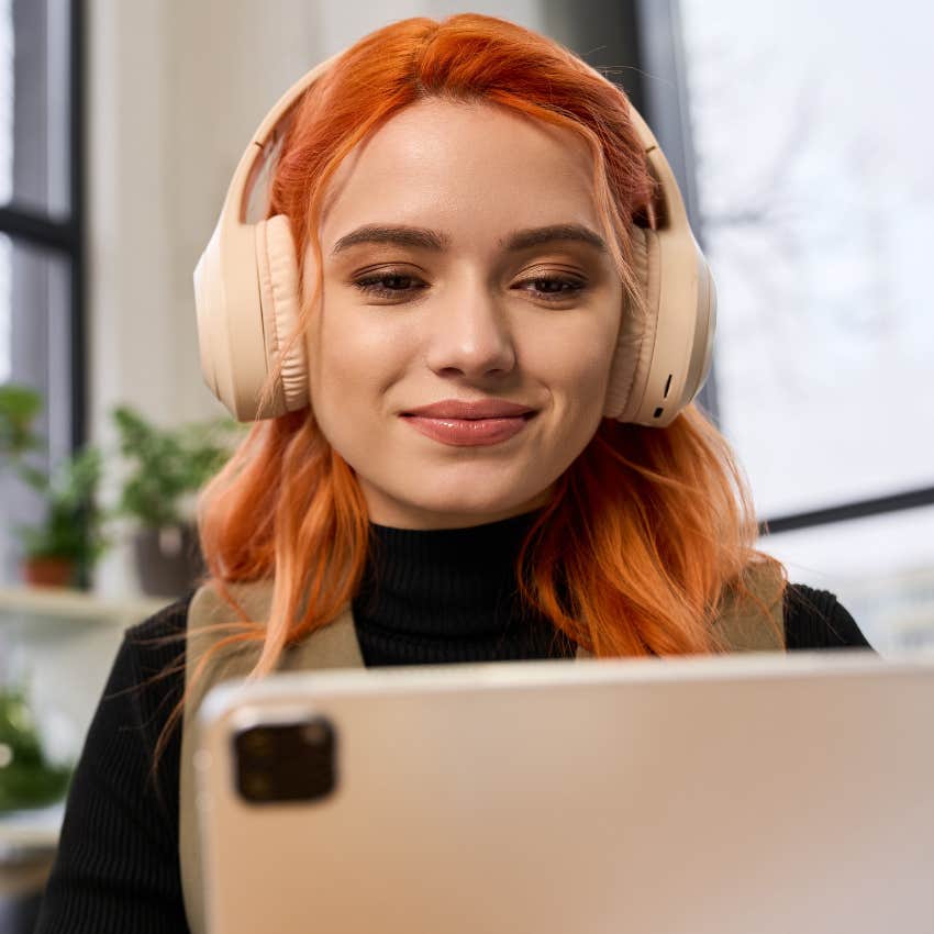 woman working on tablet wearing headphones