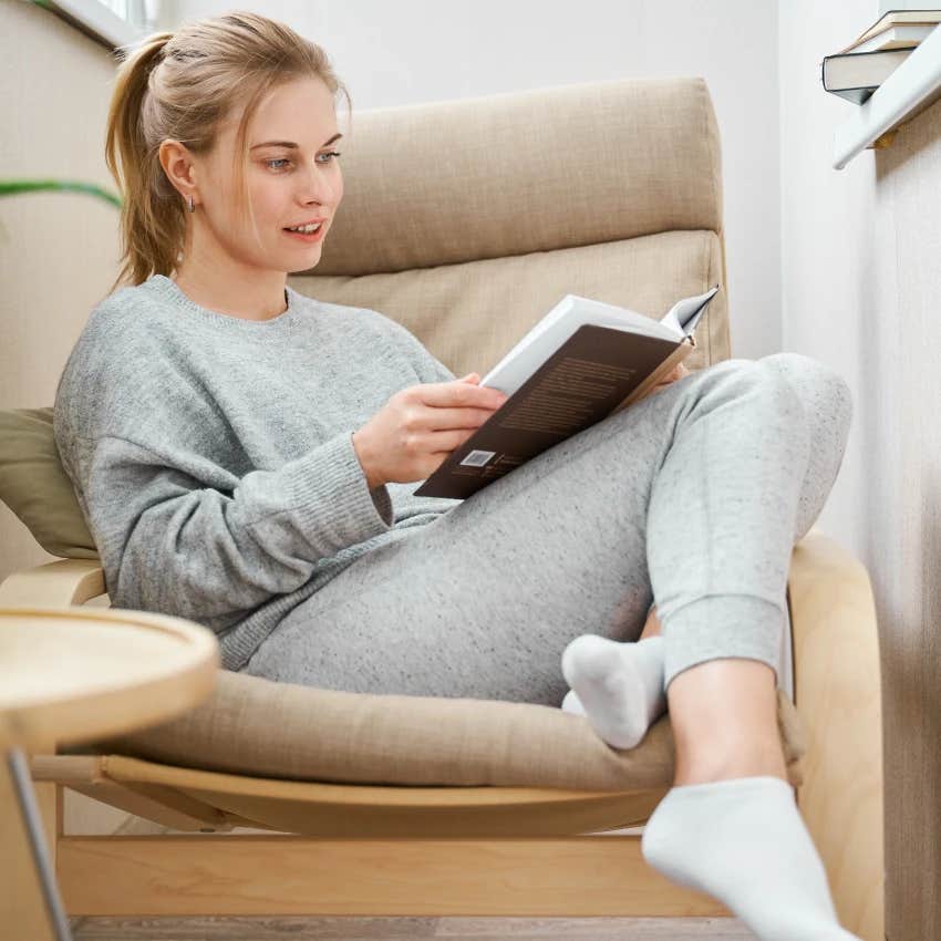 woman reading a book instead of scrolling on her phone