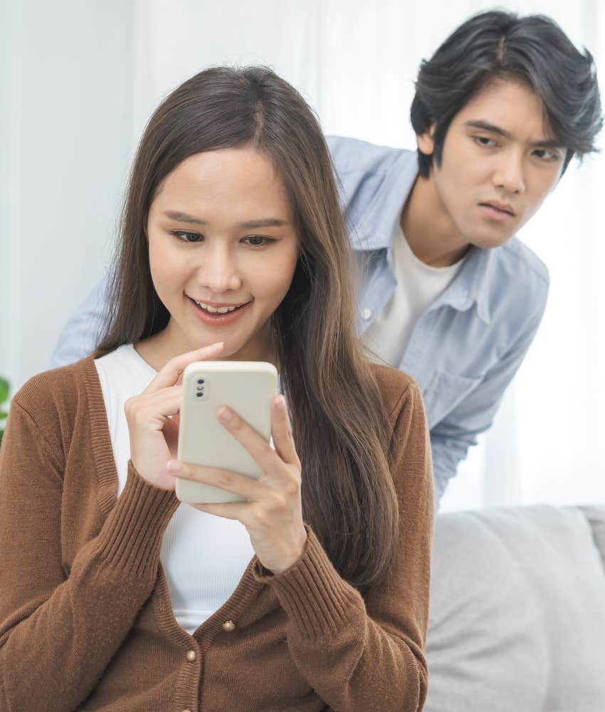 suspicious person looks over partner's shoulder showing lack of trust
