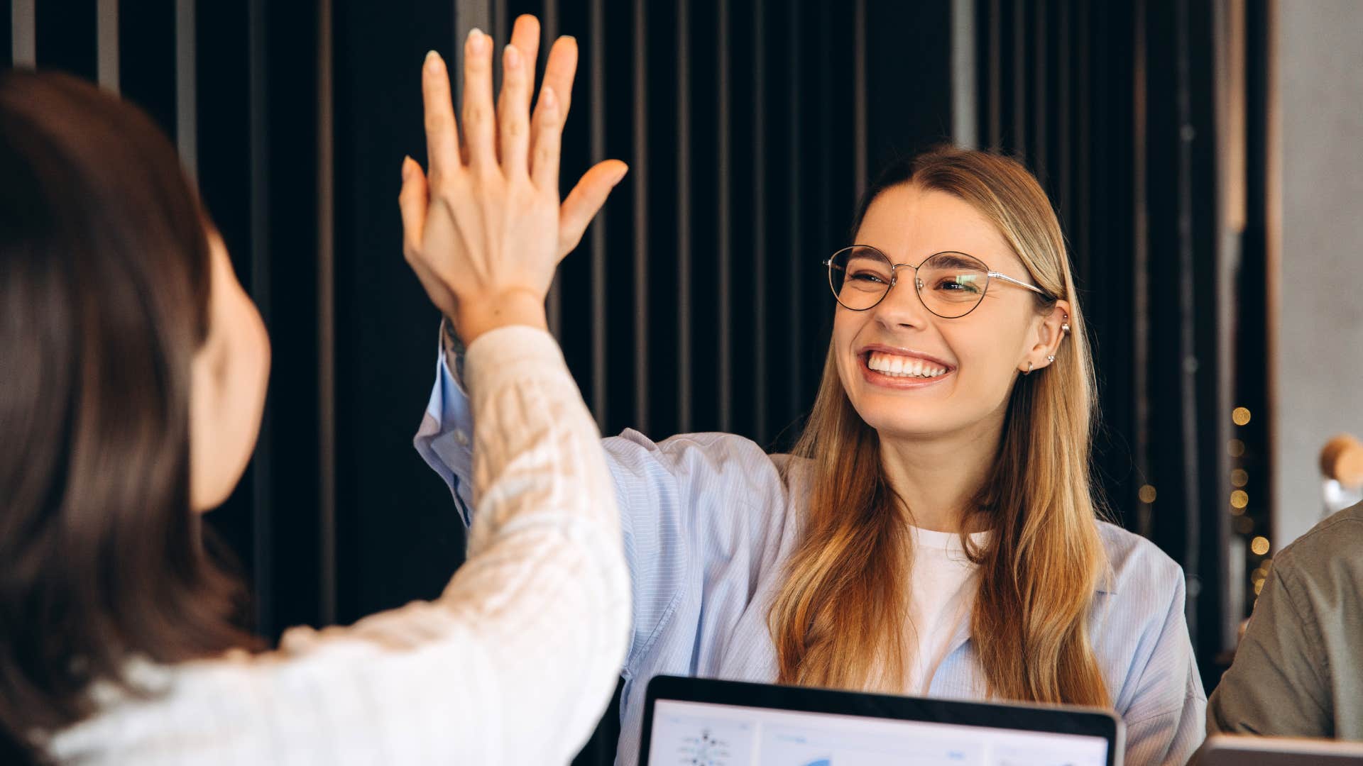 co-workers high fiving celebrating their achievements