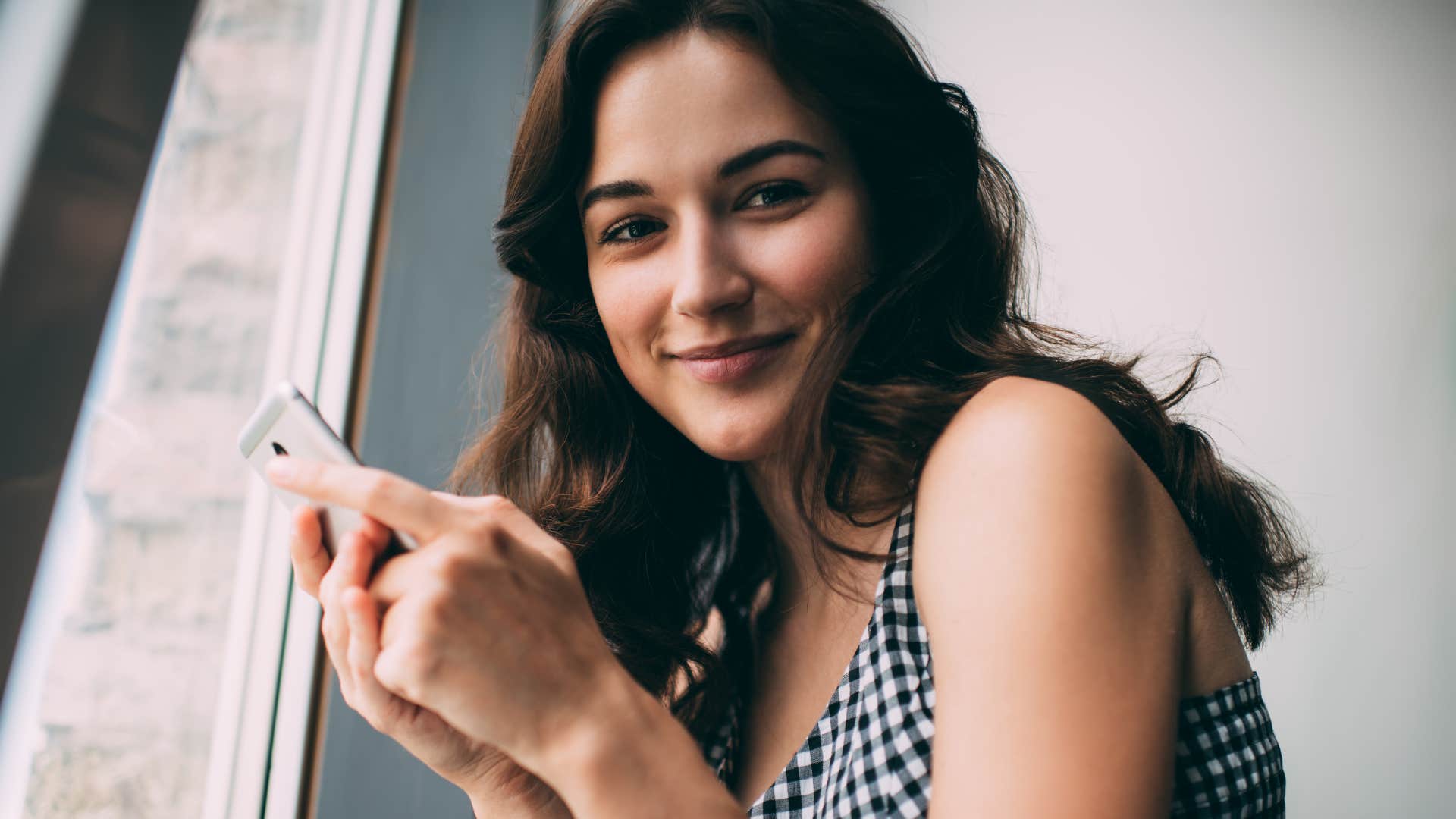 happy woman on her phone no longer caring about instant gratification