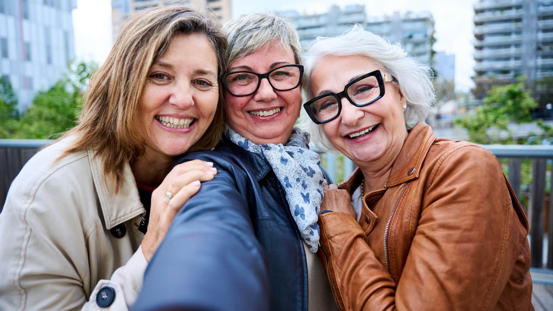 happy and small group of friends taking a selfie together